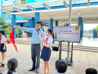Hướng dẫn cách thắt thảo khăn quàng cho các em học sinh khối lớp ba trước khi lễ kết nạp đội.